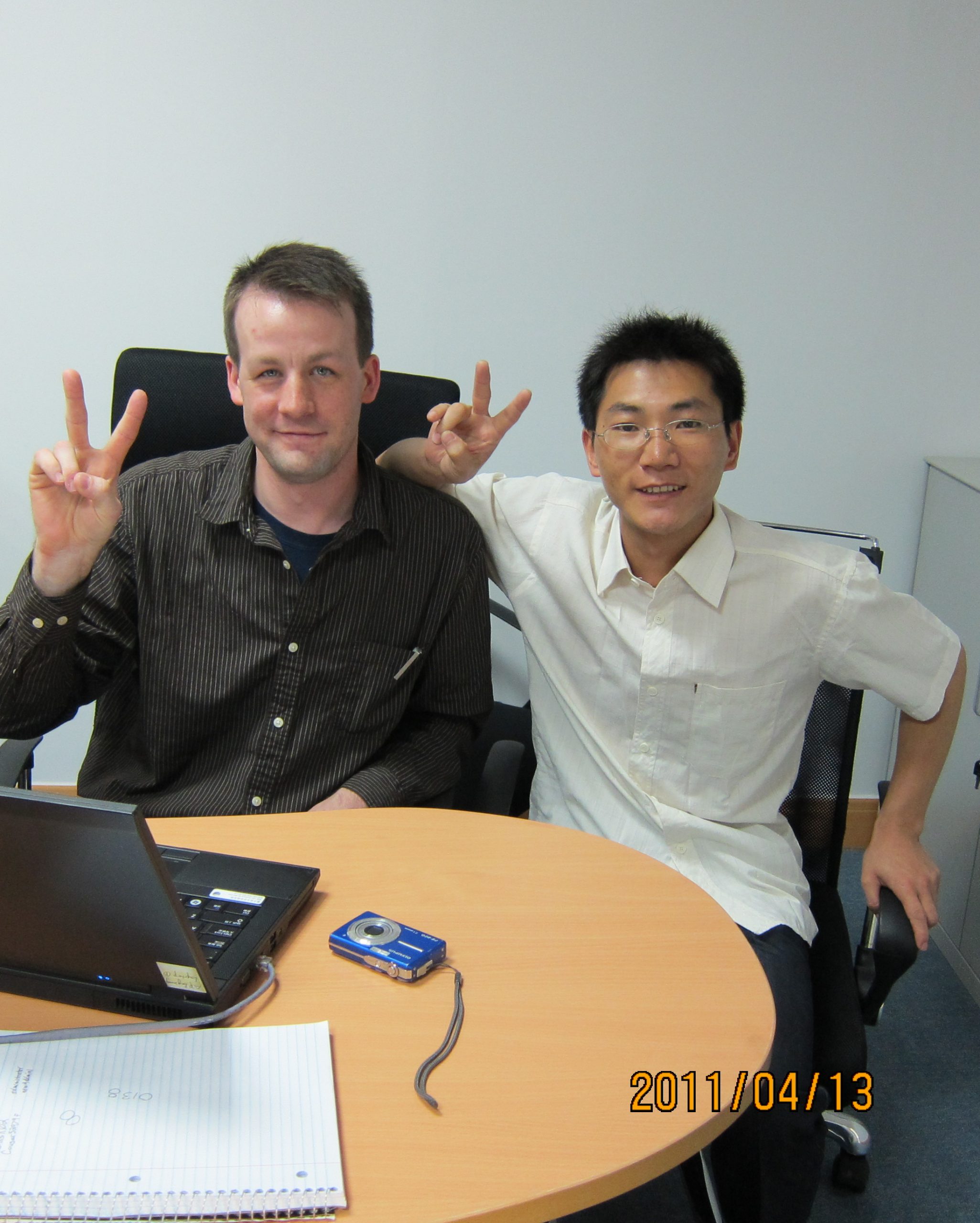 An American buyer and a Chinese supplier giving peace sign.